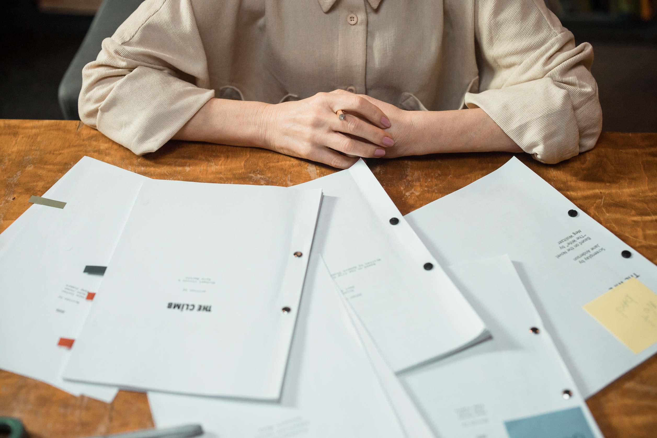Bürotisch mit Ordnern und Papierstapeln, Close-up Hände mit Geschäftsunterlagen